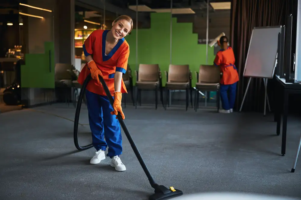 Cleaner hoovering an office floor